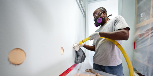 man installing wall insulation